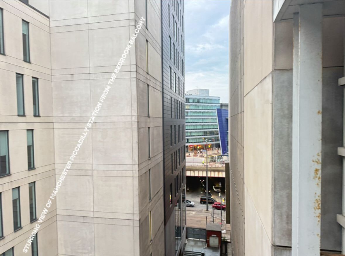 Uitzicht vanaf een hoog gebouw op een straat met auto's en een gebouw met een blauwe gevel.