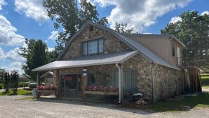 A stone building with a metal roof, a covered porch, and a sign that reads "FIREWORKS". - Happy Pappys - Store Cabin (Current Township)