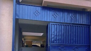 A blue gate with diamond patterns, leading to a covered entrance area with a car parked inside. - G1 Studio with a lift,balcony &underground parking (Nairobi)