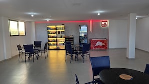 Un interior moderno con zona de comedor, un bar de aperitivos y un cartel de Redmart.