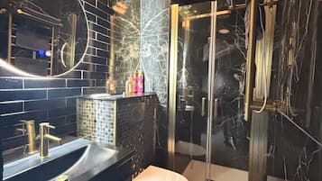 Een douche, handdoeken, zeep, toiletpapier