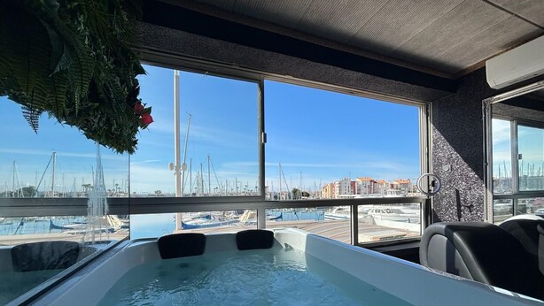 A hot tub with a view of a marina and buildings in the background.