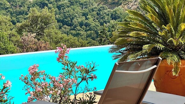 A pool area with a view of a castle on a hill.