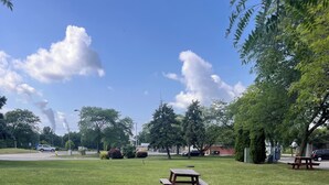 A grassy park area with a picnic table and benches. - Stay-Well Inn  (Monroe)