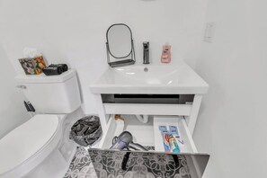 Een douche, handdoeken, zeep, toiletpapier