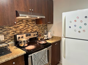 Een koelkast, een microgolfoven, een oven, keukenpapier