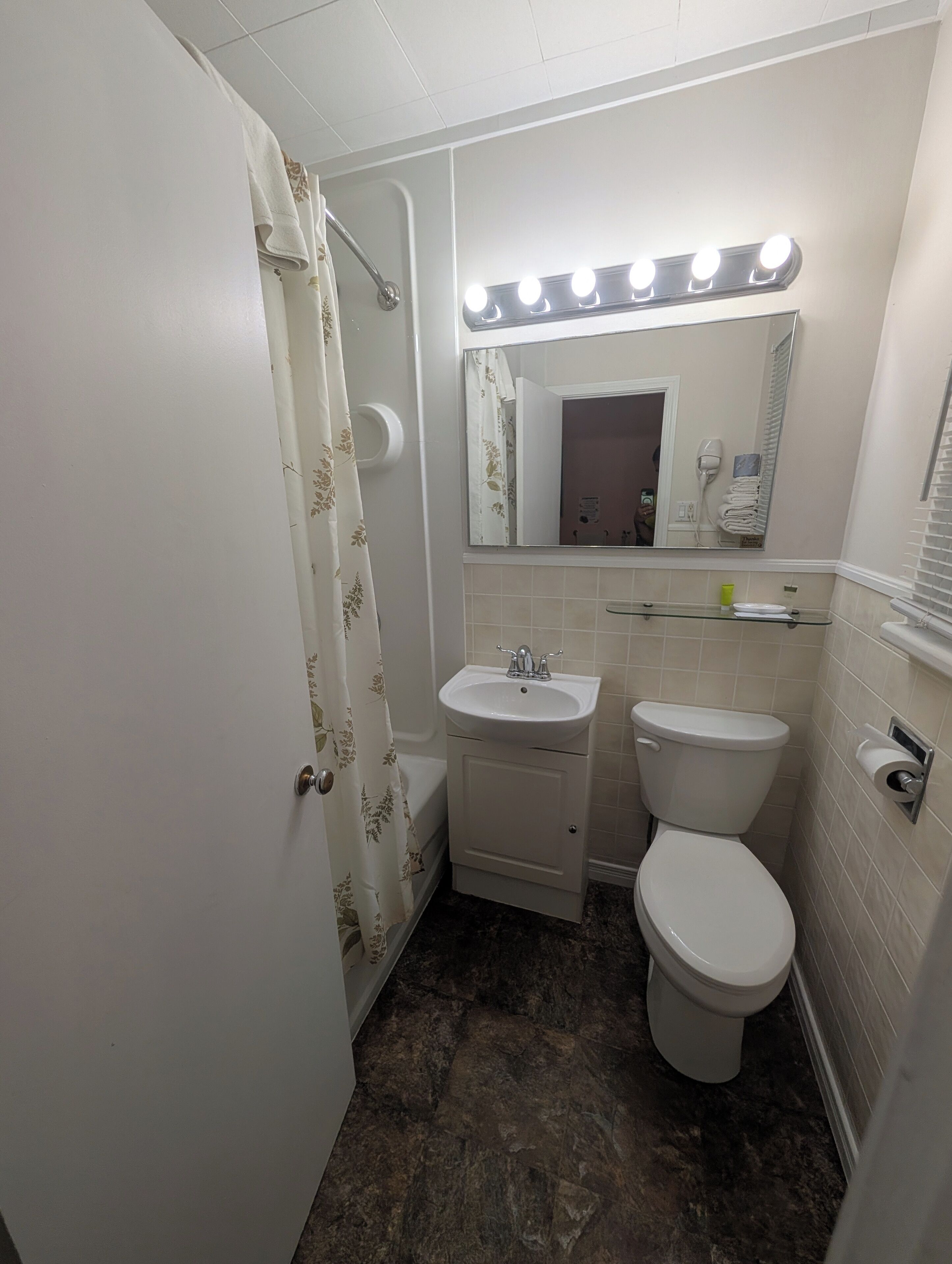 Een badkamer met een wastafel, toilet en douche met gordijn.