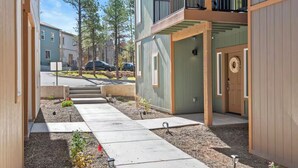Un immeuble d’appartements moderne doté d’une cour intérieure, de balcons en bois et d’un jardin bien entretenu.