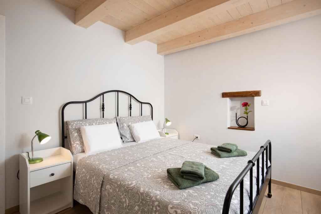 Ein Schlafzimmer mit einem Bett, Nachttischen, einem an der Wand befestigten Regal mit einer Pflanze und einem Holzbalken an der Decke.