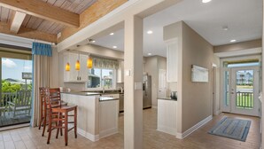 A spacious kitchen with a central island, wooden chairs, and pendant lighting. - Point of View: Saltwater Pool, Hot Tub, Amazing Ocean and Sound Views (Duck)