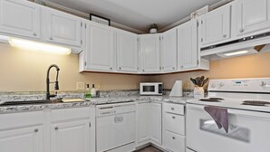 A kitchen with white cabinets, a microwave, a dishwasher, and a stove. - Charming Guest House – 1BR + Sleeping Nook, Full Kitchen, Gazebo, & Boat Parking (Marshall)