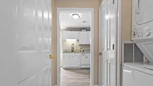 A hallway leading to a kitchen with white cabinets and a countertop. - Charming Guest House – 1BR + Sleeping Nook, Full Kitchen, Gazebo, & Boat Parking (Marshall)