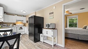 A compact kitchen with white cabinets, a black refrigerator, and a microwave on a wooden countertop. - Charming Guest House – 1BR + Sleeping Nook, Full Kitchen, Gazebo, & Boat Parking (Marshall)