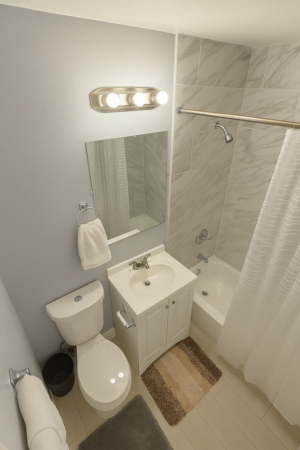 Ein Badezimmer mit Toilette, Waschbecken, Spiegel und Dusche.