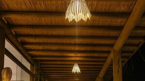 Une terrasse extérieure en bois avec une piscine, des meubles en bois et des guirlandes lumineuses.