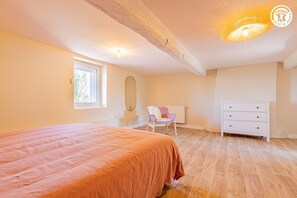 A bedroom with a bed, a chair, a dresser, and a window. - Chez Jean - BOIS SAINTE MARIE (BOIS SAINTE MARIE)