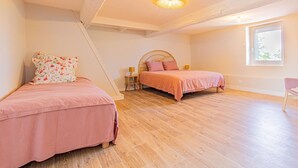 Un dormitorio con dos camas, una ventana y una lámpara en el techo.