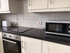 Eine Küche mit Mikrowelle, Toaster und Backofen.
