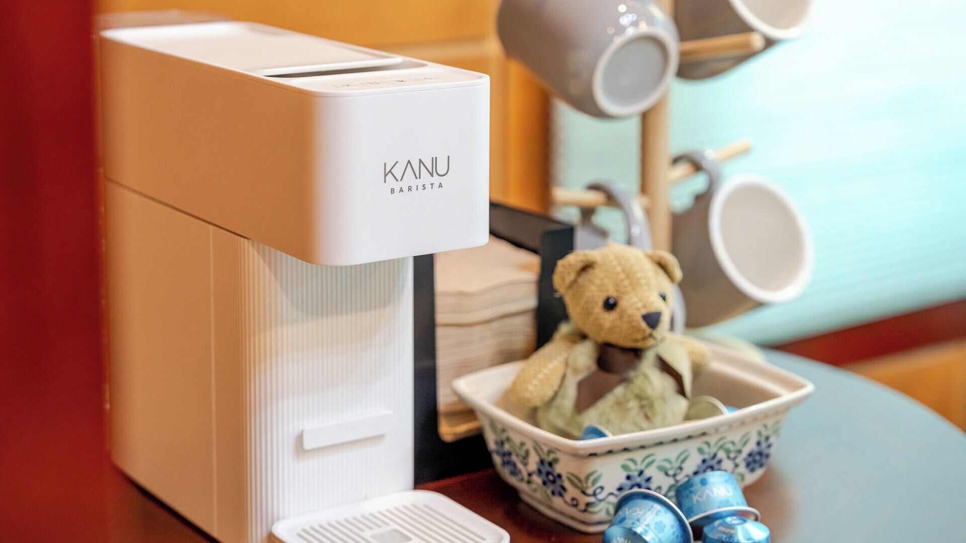 A coffee machine with a white exterior and the brand name 'KANU' on it.