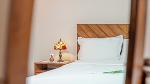 A neatly made bed with white linens, a wooden headboard, and a bedside table with a decorative lamp. - Ganghwa Pureunbam Private Pension (Incheon)