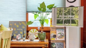 A room with a window, a plant, a shelf with books, and a decorative item. - Ganghwa Pureunbam Private Pension (Incheon)