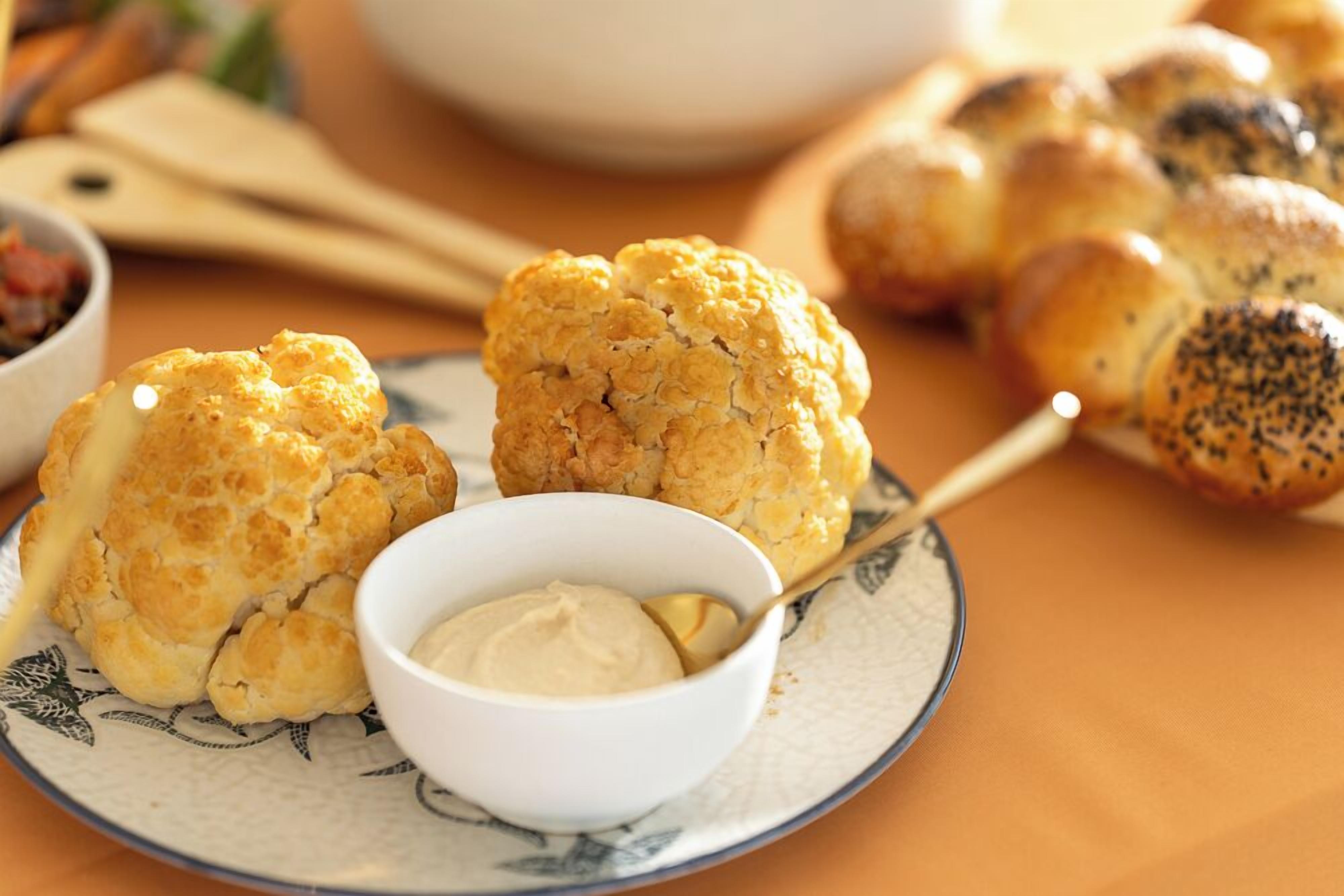 Une assiette avec deux biscuits dorés et une petite coupelle de beurre.