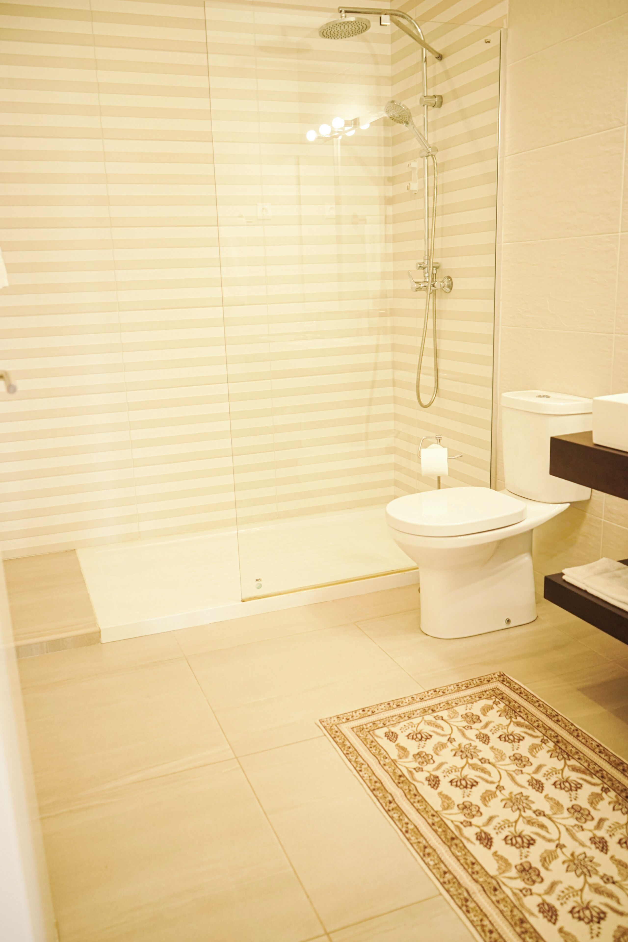 Une salle de bain moderne avec une douche à parois de verre, des toilettes et un lavabo.