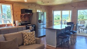 Un interior de madera con sofá, comedor, cocina y ventilador de techo.