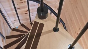 Una escalera de caracol con escalones de madera y barandillas de metal.