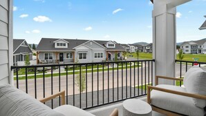 A balcony with a view of a residential street and houses. - Modern 6br near skiing, luxe, sleeps 12, hot tub (Heber City)