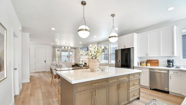 A modern kitchen with white cabinetry, a large island, stainless steel appliances, and pendant lighting. - Modern 6br near skiing, luxe, sleeps 12, hot tub (Heber City)
