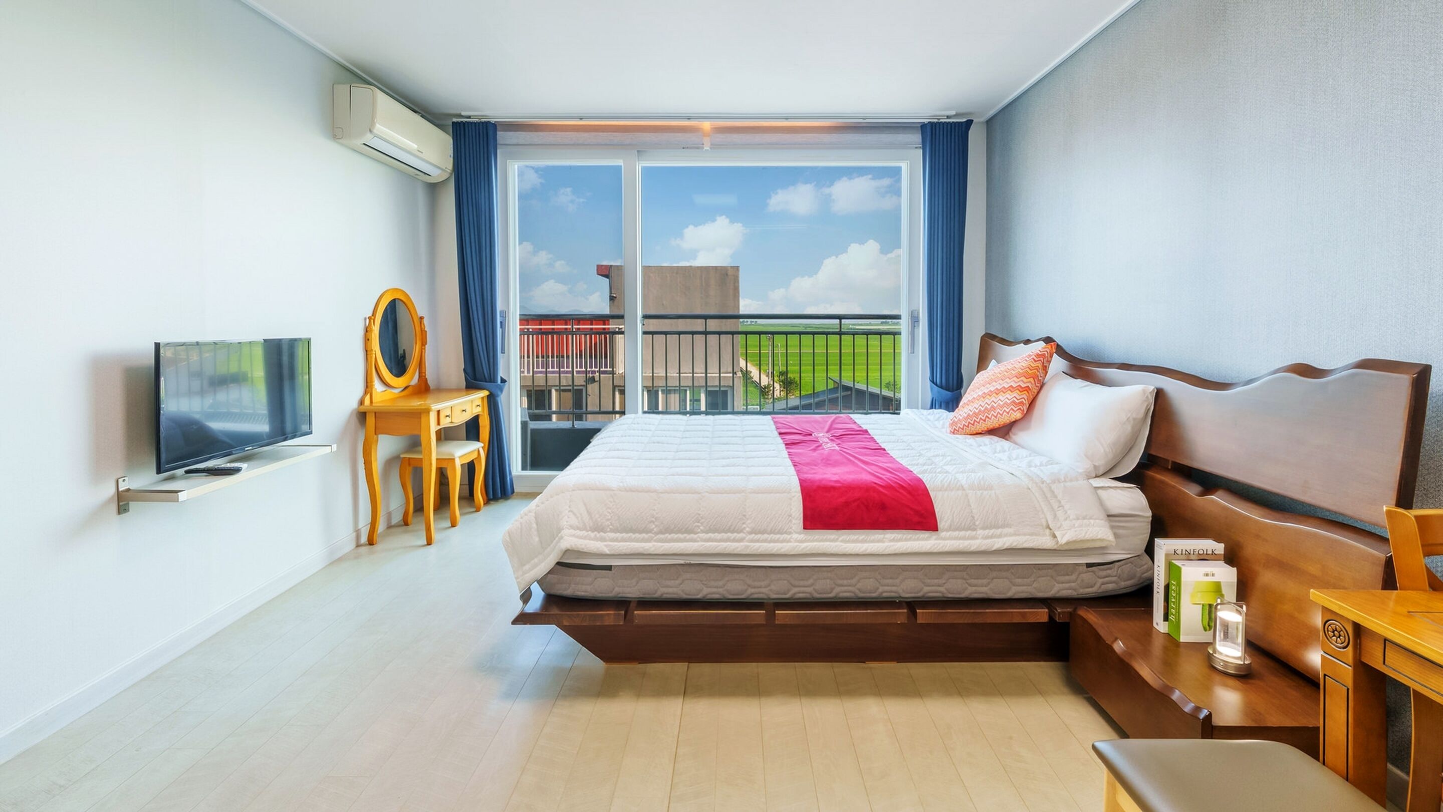 Quarto de hotel com uma cama, televisão, escrivaninha e uma cadeira.