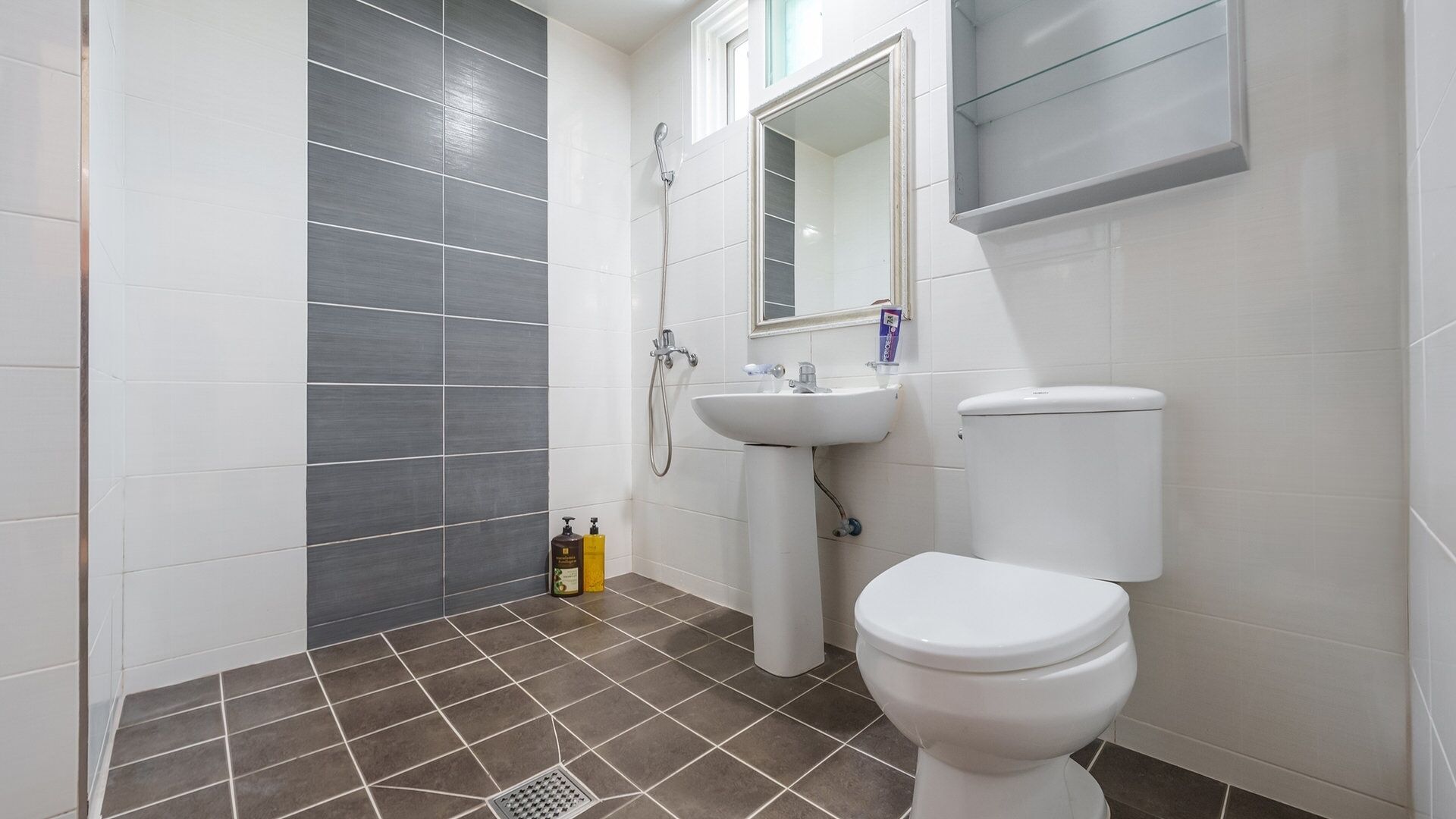 A bathroom with a toilet, sink, and shower.