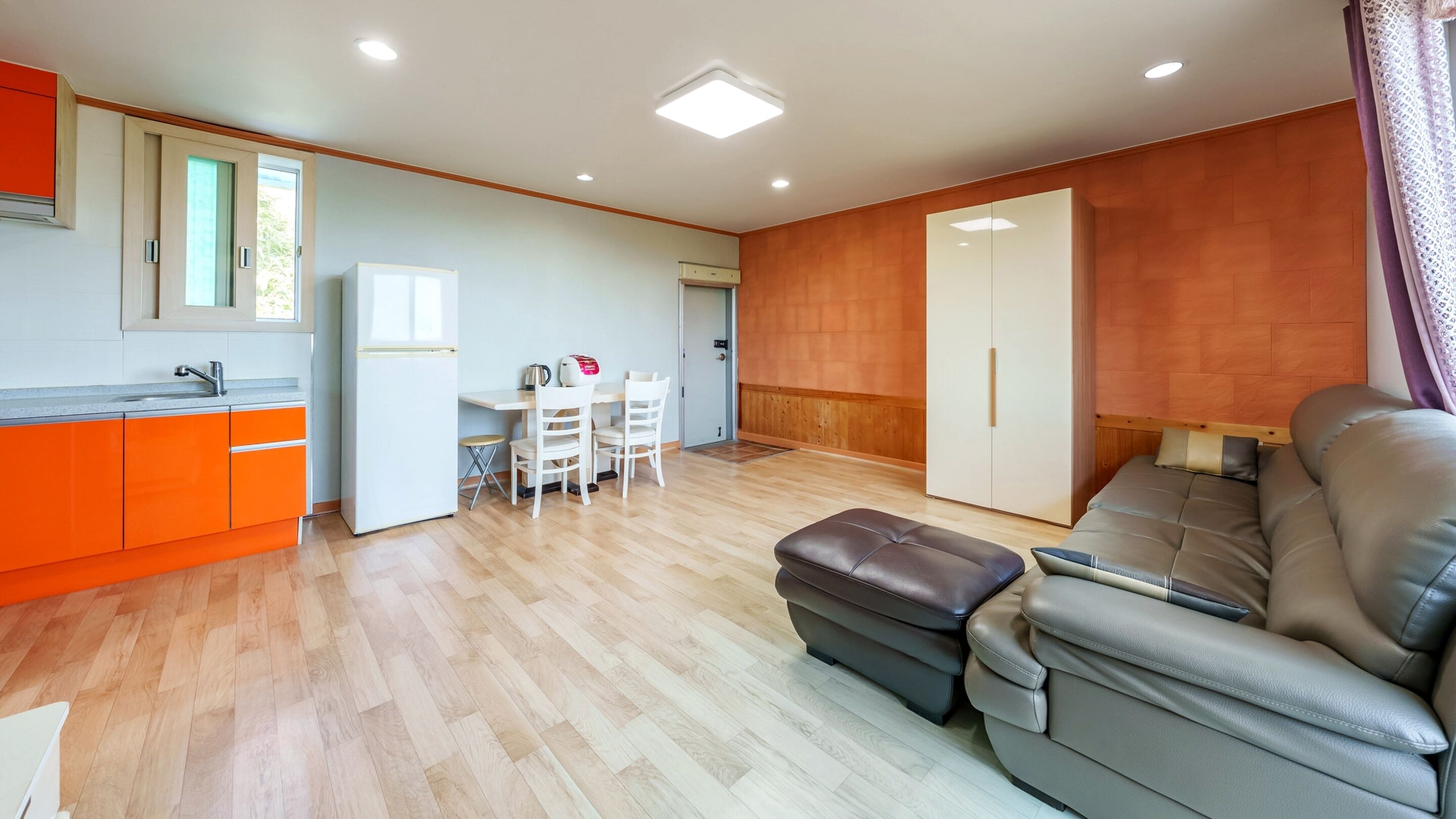 A modern apartment with a kitchen, dining area, and living room.
