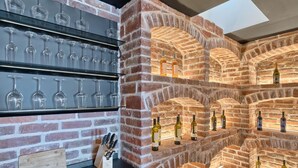 Una bodega con estantes llenos de botellas de vino y copas.