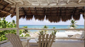 A covered outdoor seating area with two Adirondack chairs facing a beach view. - Orange Beach House 10bdr in Tulum Hotel Zone, Wake up every morning on the beach (Tulum)