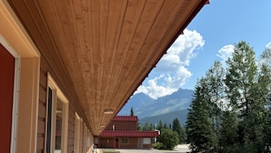A covered walkway with wooden beams, leading to a building with a red roof. - Saddle Mountain Lodge (Blue River)