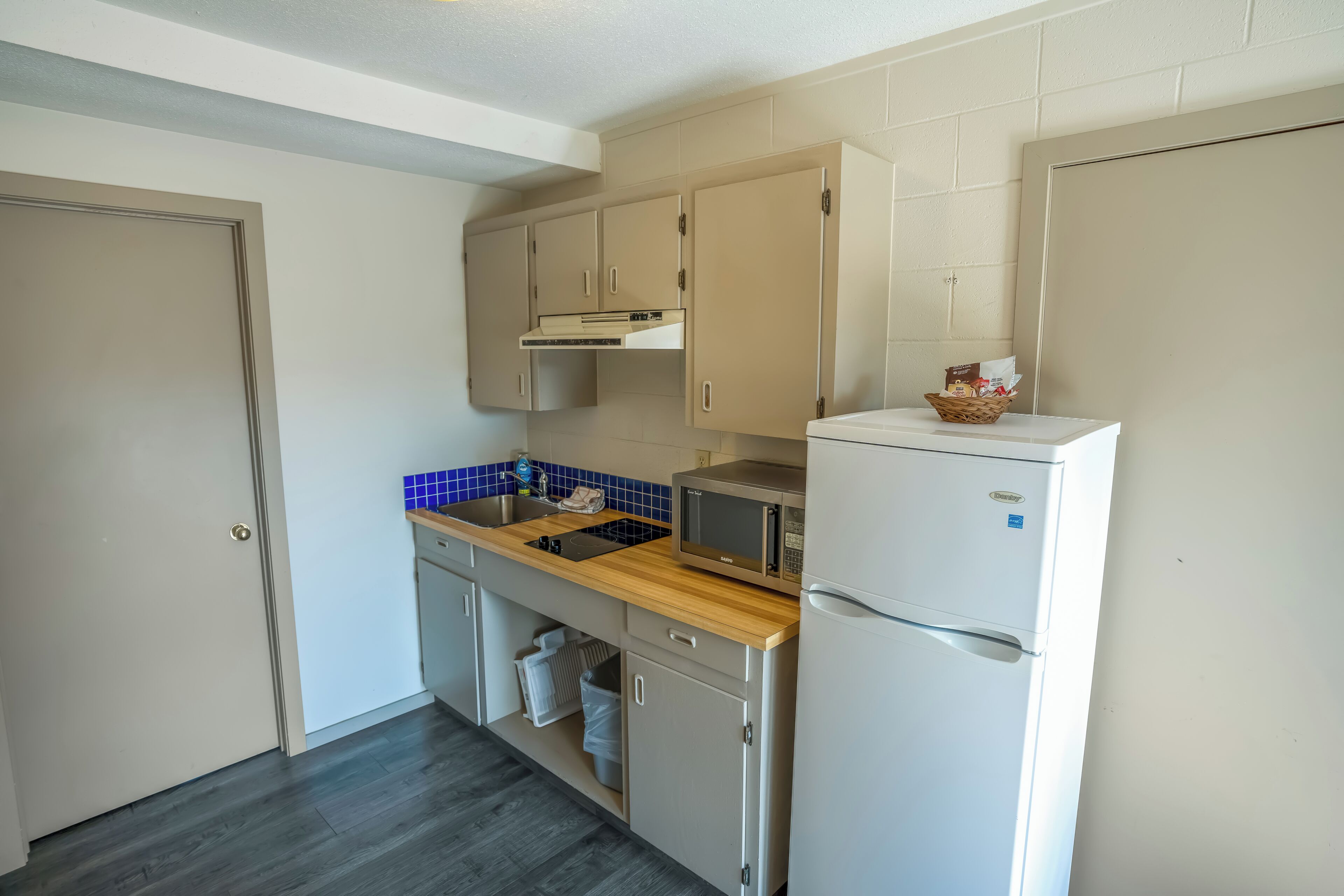 A compact kitchen with a microwave, toaster, and refrigerator.