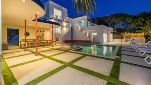 A modern house with a swimming pool, outdoor seating, and a well-lit patio area. - 5BR @ Top of The Hill  Views Surrounded by Nature (Santa Cruz)