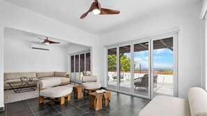 A spacious living area with a sofa set, wooden stools, and a ceiling fan. - 5BR @ Top of The Hill  Views Surrounded by Nature (Santa Cruz)