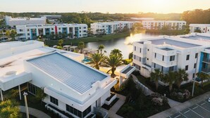 A modern hotel complex with multiple buildings, a swimming pool, and a river view. - Spacious 3BR | Pool, Gym, Near Beach and Speedway (Daytona Beach)