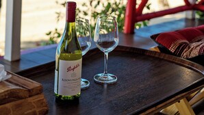 A bottle of wine and two glasses on a tray, with a view of a beach and palm trees in the background. - Oceanfront Villa at Bang Po Beach (Koh Samui)