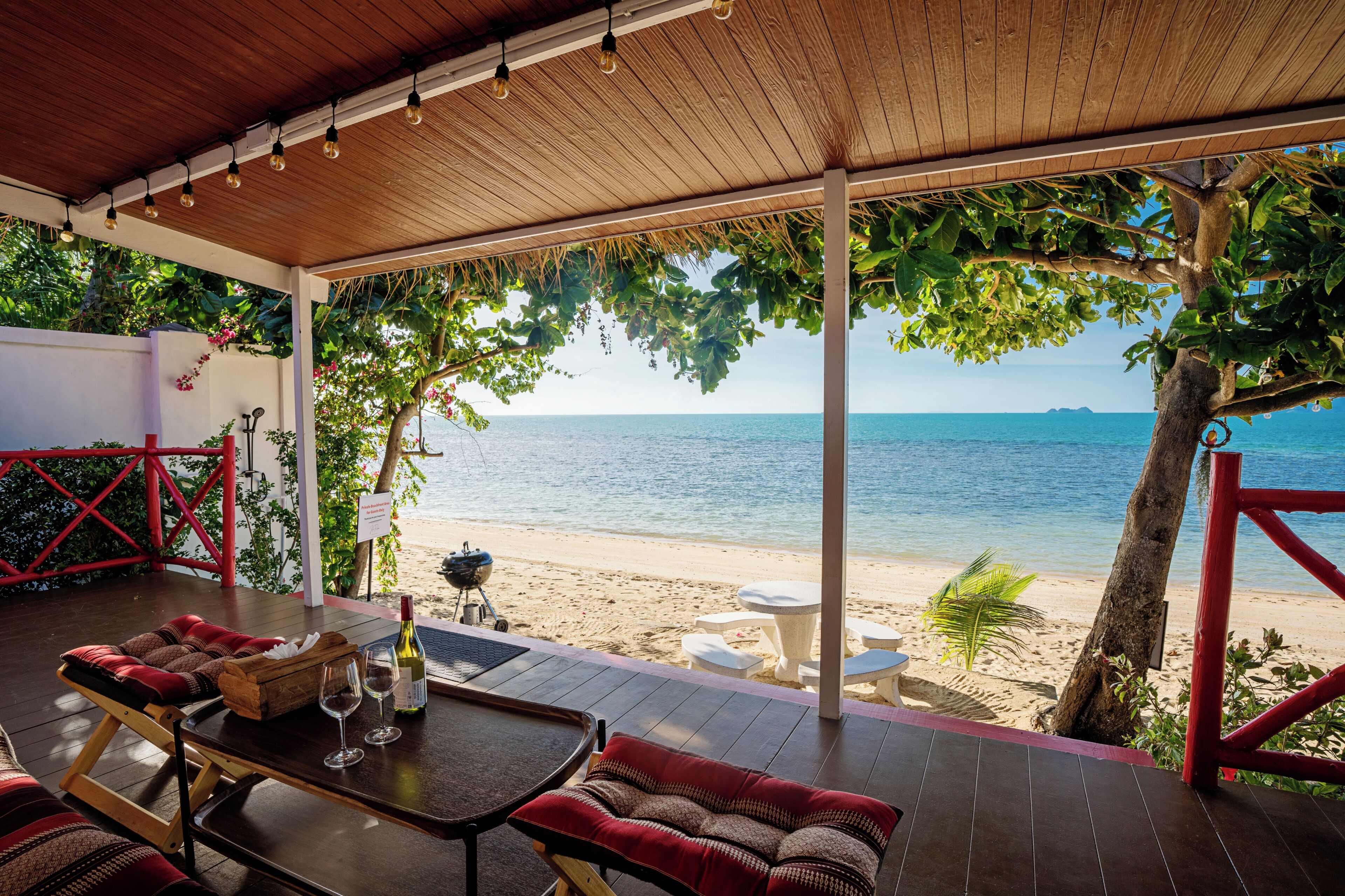 Un espacio de estar al aire libre techado, con vista a la playa y al océano.