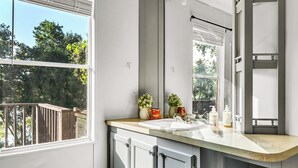 A bathroom with a large window, a sink, and cabinets. - Cozy peaceful Lake Palestine Cabin Private dock, Kayak, fire pit Wifi (Chandler)