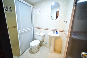 Een douche, handdoeken, zeep, toiletpapier