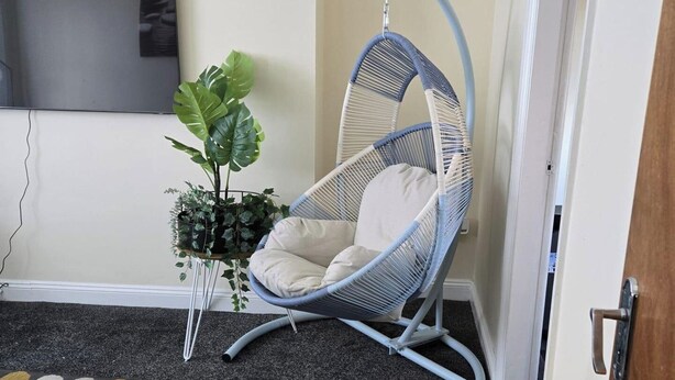 A room with a hanging chair, a potted plant, and a television on the wall. - 2 Bed - Sleeps 6 - Private Balcony - City Centre (Wolverhampton)