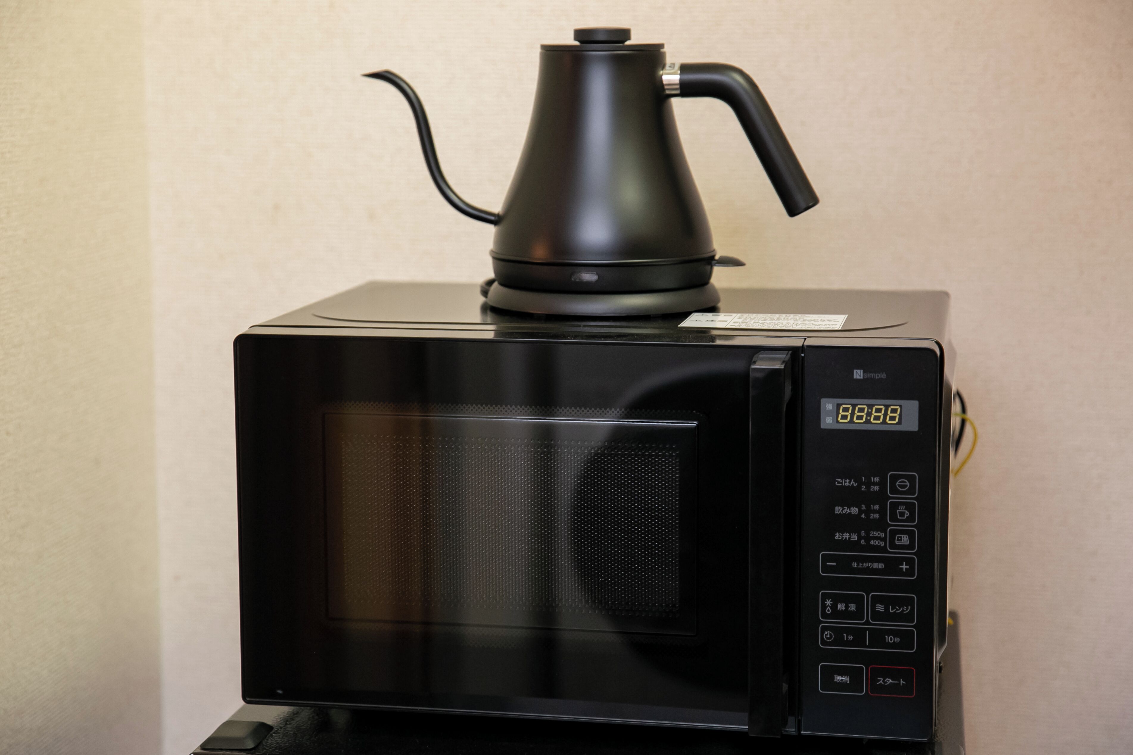 A black microwave with a digital display showing the time as 8:88.