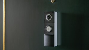 Ein an der Wand montiertes Gegensprechanlage mit Kamera und Schalter, vermutlich für den Zugang zum Zimmer oder zur Kommunikation.