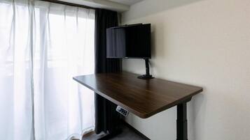 Un escritorio de pie FlexiSpot en una habitación con ventana y cortinas.