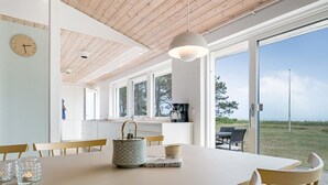 Un comedor moderno con una mesa de madera, sillas y vistas al exterior.
